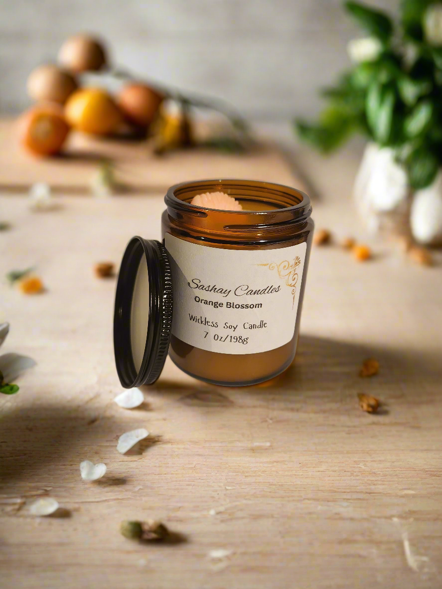 Wickless orange blossom candle neutral in color with a peg of orange 